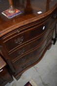 A reproduction serpentine chest of drawers, with brushing slide