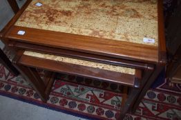 A vintage teak and tile top nest of three tables