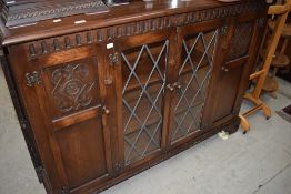 A Priory style side cabinet/bookcase having central lead glazed section flanked by cupboards