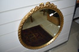 A gilt framed wall mirror with bow decoration to top