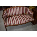 A Continental style walnut settee having shaped frame and classical striped upholstery
