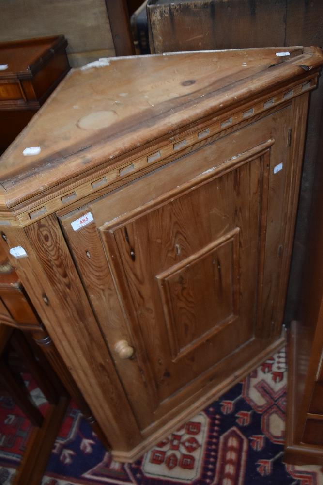 A stripped pine corner cupboard