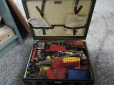 A case containing vintage Meccano including many parts, wheels, cogs, instruction booklet etc
