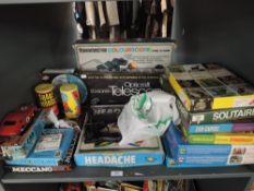 A shelf of mixed vintage Toys including Opticraft Telescope, Meccano, Headache, card Jigsaws, Airfix