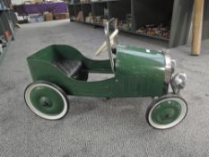 A modern reproduction Childs Pedal Car having earlier Triang steering wheel fitted having number