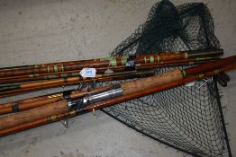 3 vintage cane or bamboo fishing rods with no markings and a similar fishing net