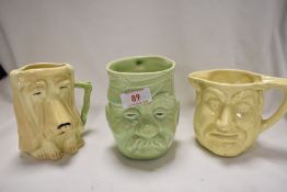 Three mid century ceramic character mugs including a dog, two headed man and military themed