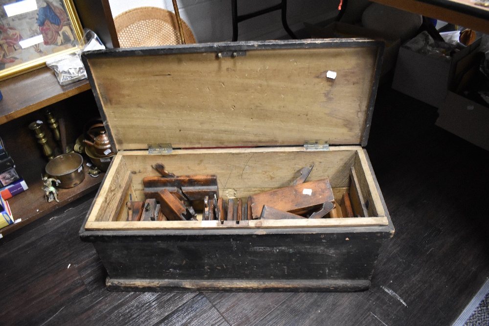 A joiners stained pine tool box, containing numerous moulding planes, mostly bearing name stamp