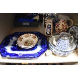 An assortment of vintage and antique ceramics, blue and white platters, fruit bowls, tea pot with