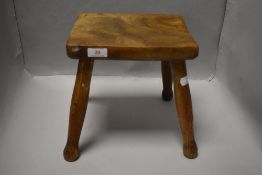 An early 20th century traditional farm house milking stool with Elm wood top