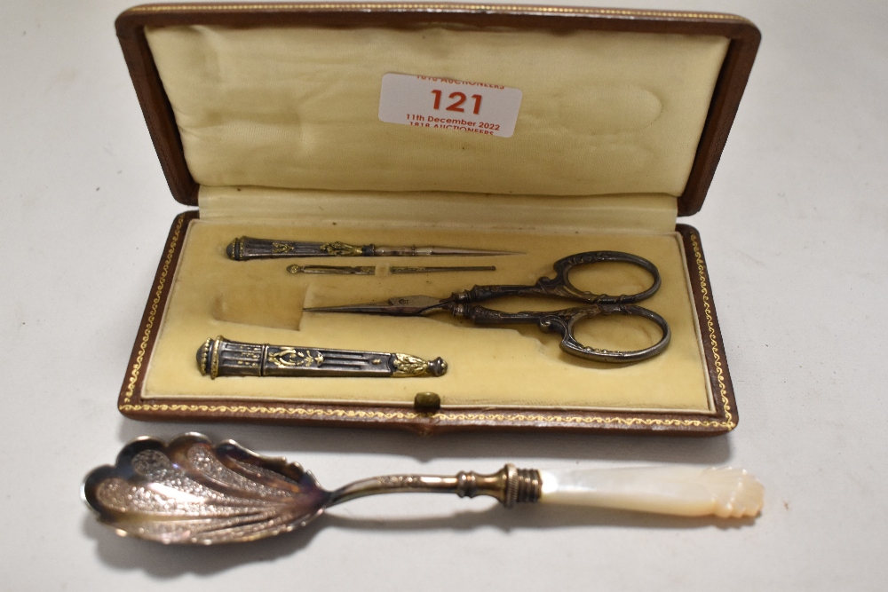 An early 20th century cased sewing kit, to include scissors, bodkin, needle case and more, also