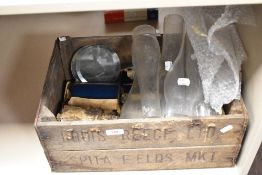 A vintage wooden advertising crate and an assortment of oil lamp chimneys, coloured glass slides and