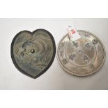 An 18th century Chinese bronze mirror having Phoenix decoration in a heart shaped design with a