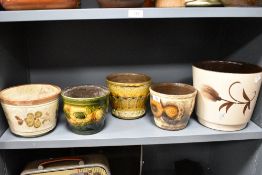 A group of five West German pottery planters, each decorated in earthy tones