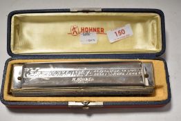 A cased Hohner 'The 64 Chromonica' harmonica/mouth organ