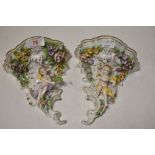 A pair of Sitzendorf Dresden porcelain wall sconces with floral and cherub designs