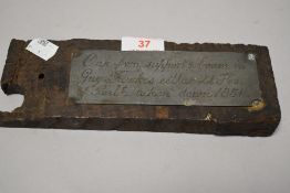 A piece of antique timber with a pewter plaque reading ' Oak from support beam in Guy Fawkes