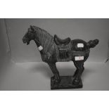 A 20th century stone carved Tang style horse figure, having repairs to base and tail. 26cm tall