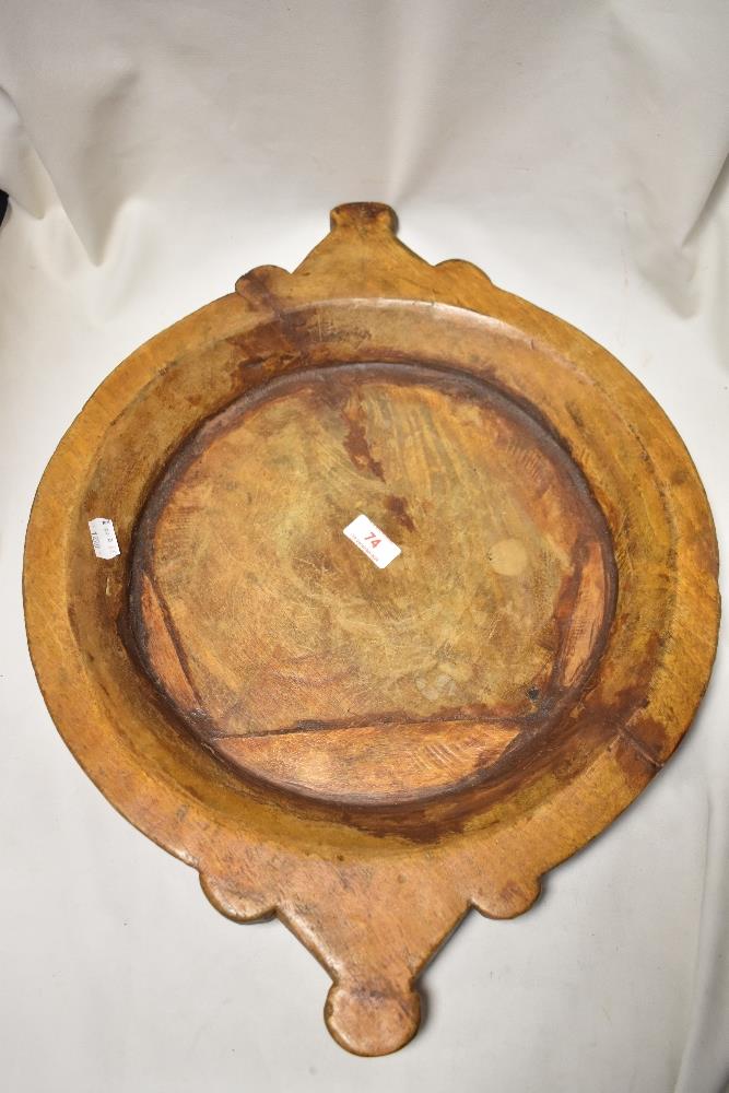 An antique wooden carved dough or bread bowl in an artisan farm house design