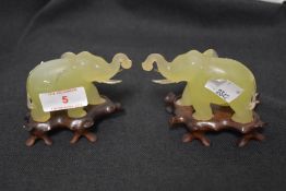 A pair of 20th century Jade stone mirrored elephant figures on wooden bases, 5cm tall approx