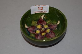 An early 20th century Moorcroft pin dish in a green glaze with anemone design