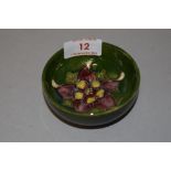 An early 20th century Moorcroft pin dish in a green glaze with anemone design