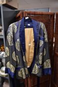 A mid century oriental smokers jacket in blue silk satin having gold thread embroidery with a set of