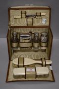 An 30's ladies vanity case, in tooled leather having cosmetic bottles and hair brushes