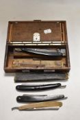 A box full of antique cut throat razors.