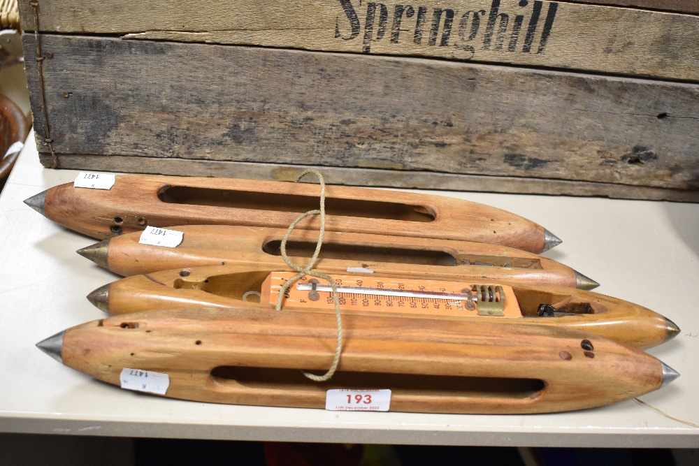 A group of four vintage wooden loom shuttles.