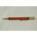 A Parker Duofold Junior propelling pencil in orange. Initials scratched into barrel