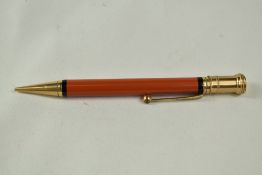 A Parker Duofold Junior propelling pencil in orange. Initials scratched into barrel