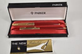 A boxed Parker 61 cartridge fountain pen and propelling pencil set in red with rolled gold cap.