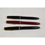 Three Parker Slimfold aeromatic fill fountain pens two in black one red, having decorative band to