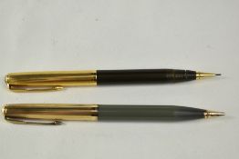 Two Parker 51 propelling pencils. One sage green and one brown with gold filled caps. The brown is