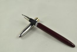A Sheaffer Sentinel TM snorkel fountain pen in burgundy having steel cap with gold trim and white