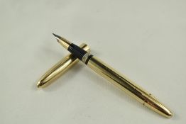 A Sheaffer Triumph Touchdown snokel fountain pen in gold fill with lined design and white spot to