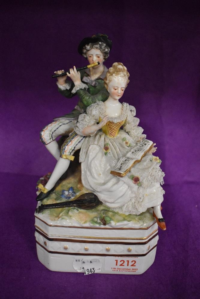 A German made porcelain lidded container with 18th century couple playing music in a Dresden style.