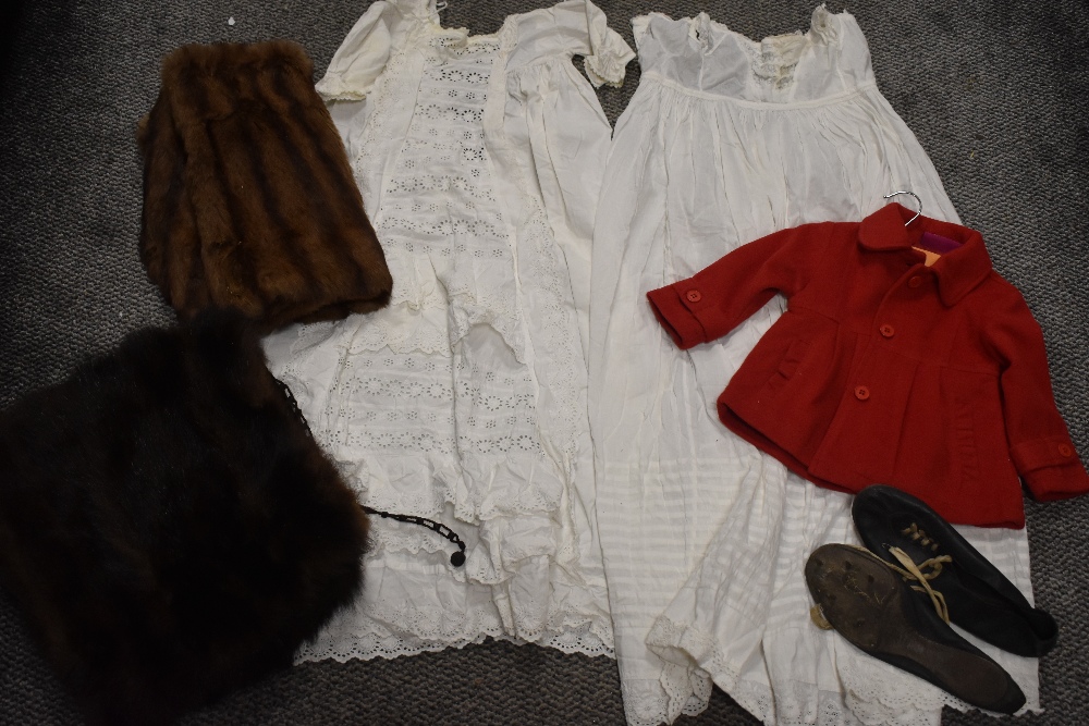 A selection of vintage textiles including childs red jacket, fur collars and night dress