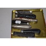 Seven pocket or pen knives including metal, horn and carved wood handles
