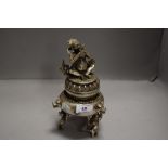 A Tibetan / Chinese Koro cast in white metal with Hindu deity sat on lotus leaf plinth 23cm tall