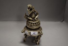 A Tibetan / Chinese Koro cast in white metal with Hindu deity sat on lotus leaf plinth 23cm tall