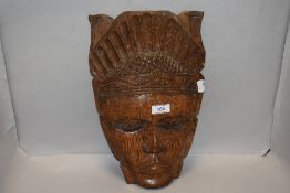 A wooden South American hand carved native wooden mask