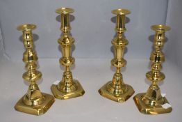 Two pairs of vintage brass cast candle sticks measuring 26cm tall