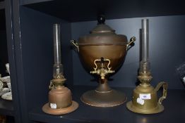 Two antique brass cased chamber stick style oil lamps with a copper samovar