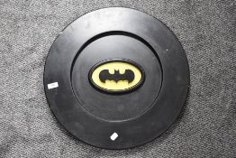 A wooden circular batman sign or plaque