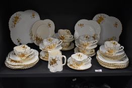 An antique Wileman Foley Shelley part tea service in a cream and gilt design, Rd. 60650, pat no