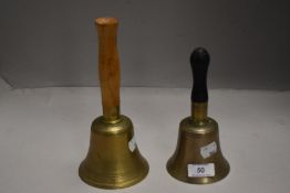 Two vintage hand bells having turned wood handles with cast brass bells