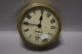 An early 20th century brass cased nautical ships clock, heavy set with bevelled glass and in working