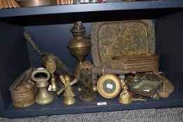 An assorted selection of vintage brass wares including paper weights, trays, lamp and fire side